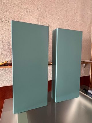 Mueble baño turquesa con lavabo y dos estanterias.