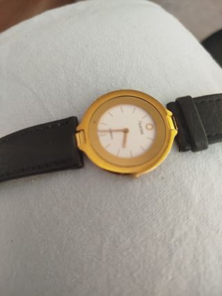Reloj Racer dorado...la pulsera es de piel negra.