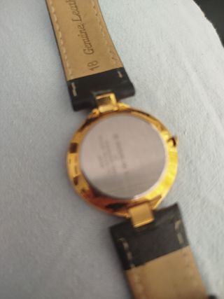 Reloj Racer dorado...la pulsera es de piel negra.
