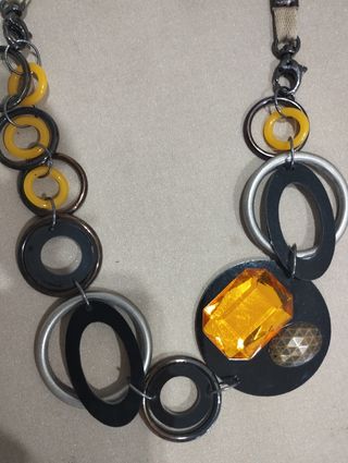 Collar de piezas circulares en negro y amarillo.