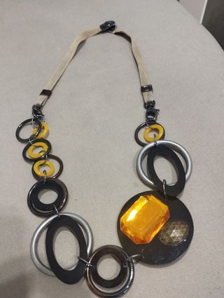 Collar de piezas circulares en negro y amarillo.