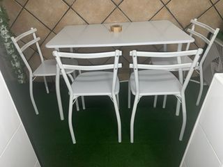Mesa y 4 sillas blancas de metal y plástico