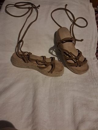 Sandalias planas marrones atadas al tobillo