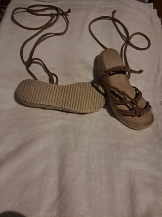 Sandalias planas marrones atadas al tobillo