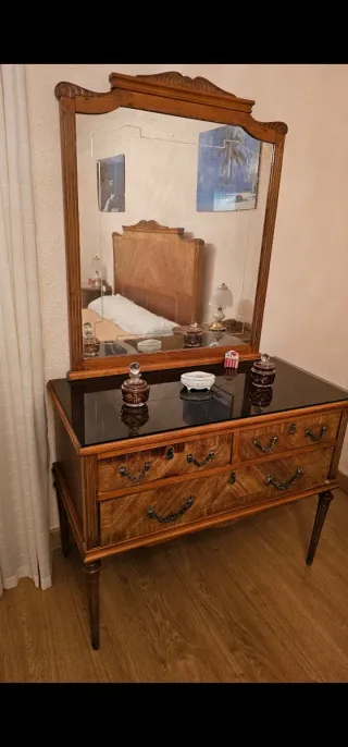 Cama vintage de madera y tocador con espejo.