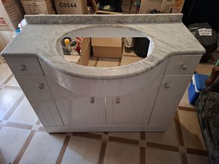 Mueble baño blanco con piedra de marmol y lavabo