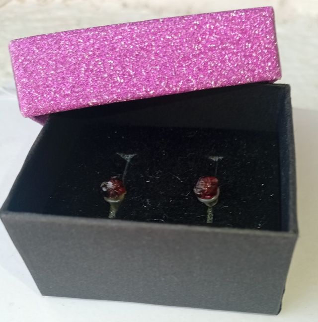 Un pendiente de granate rojo en crudo. Arete