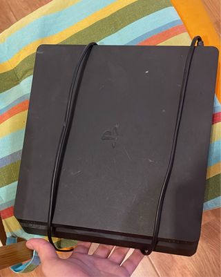 PS4 Slim con mando y un juego