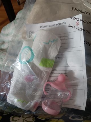 Muñeco reborn bebé, morenito, con pelo rizado.