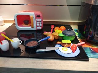 Microondas para niños con utensilios para cocinar.