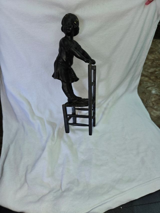 Figura bronce ñiña sobre silla antigua