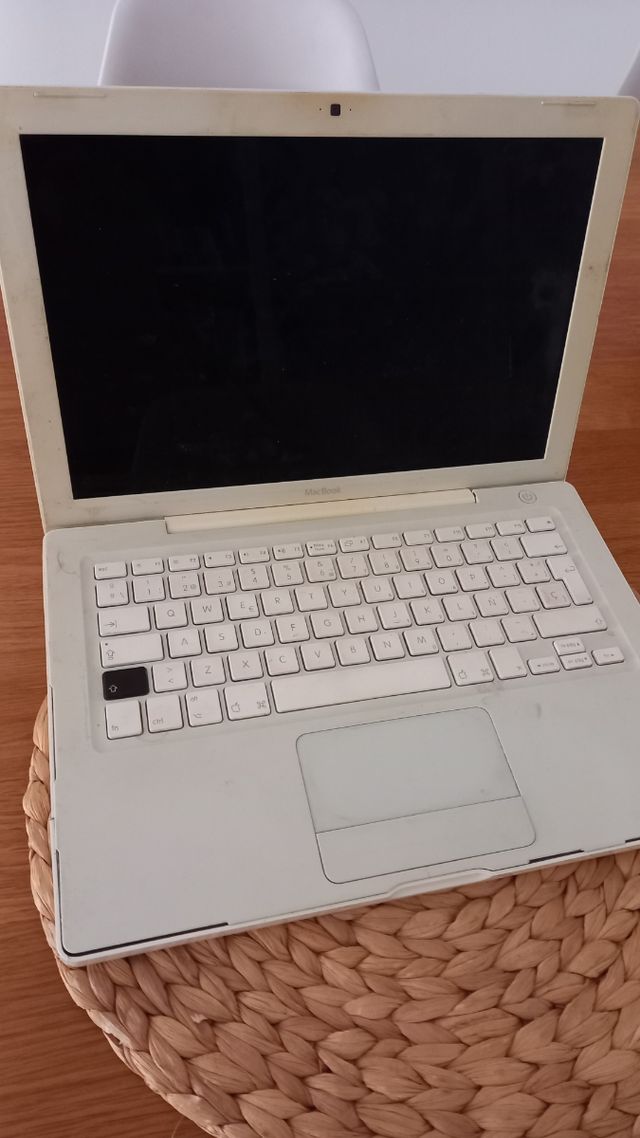 MacBook blanco Apple con cargador.
