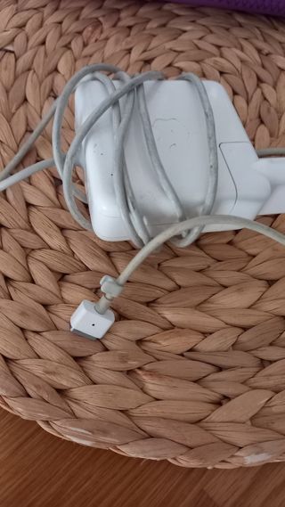 MacBook blanco Apple con cargador.