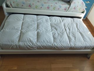 Cama nido infantil blanca y azul.