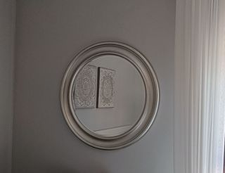 Espejo redondo con marco plateado.