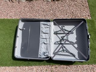 Maleta rígida grande gris con ruedas y perchas.