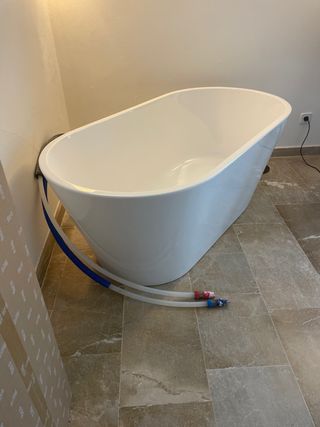 Bañera independiente blanca con grifo de Roca 