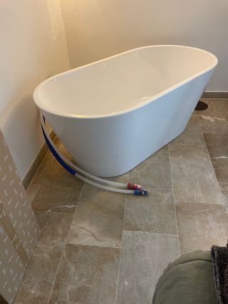 Bañera independiente blanca con grifo de Roca 
