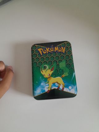 Caja metálica Pokémon con muchas cartas dentro 
