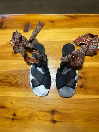 Sandalias romanas negras con cintas rojas