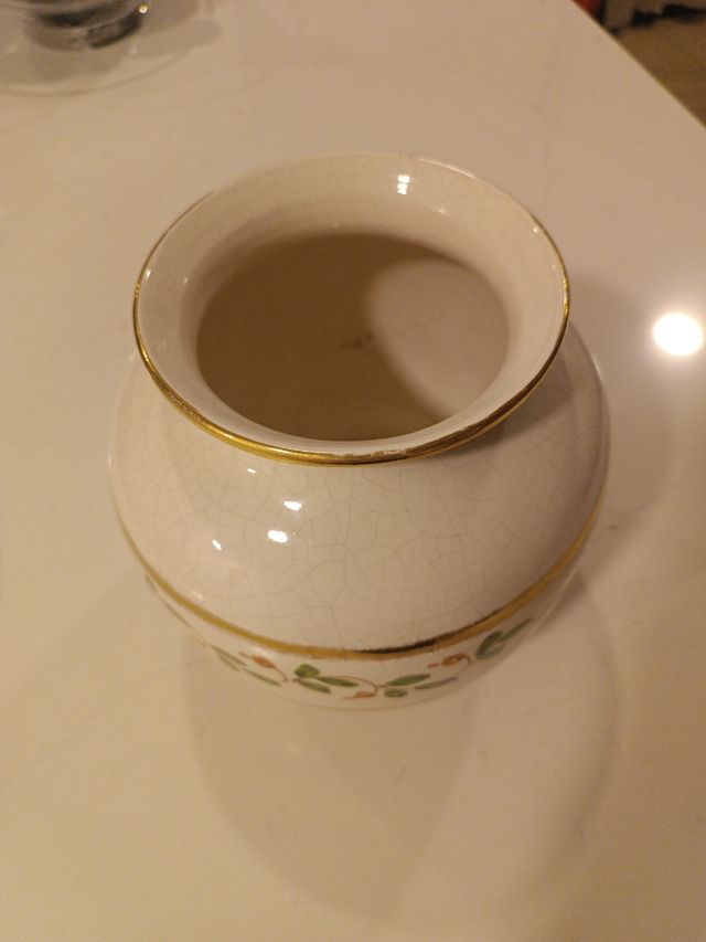 Vaso in ceramica bianca e dorata con fiori.