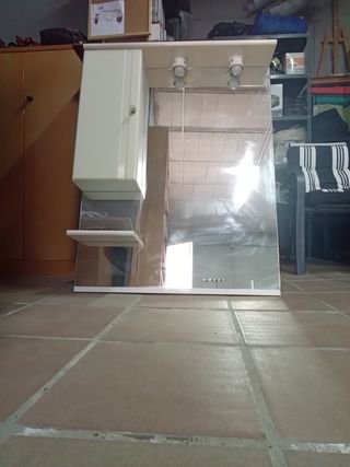 Espejo de baño con luz, estante y armario anexo.