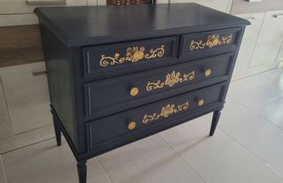 Cómoda vintage azul marino y cenefas doradas.