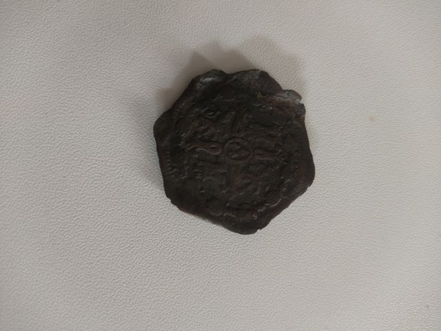 Moneda antigua con señales de uso.