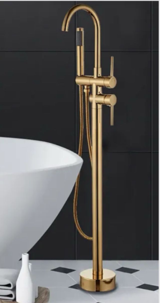 Bañera isla, acrílica blanca y grifería dorada.