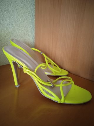 Sandalias amarillas neón tacón alto.