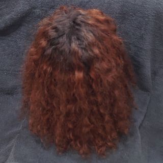 Peluca natural rizada rojiza.