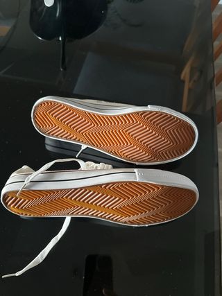 Zapatillas blancas tipo Converse. 