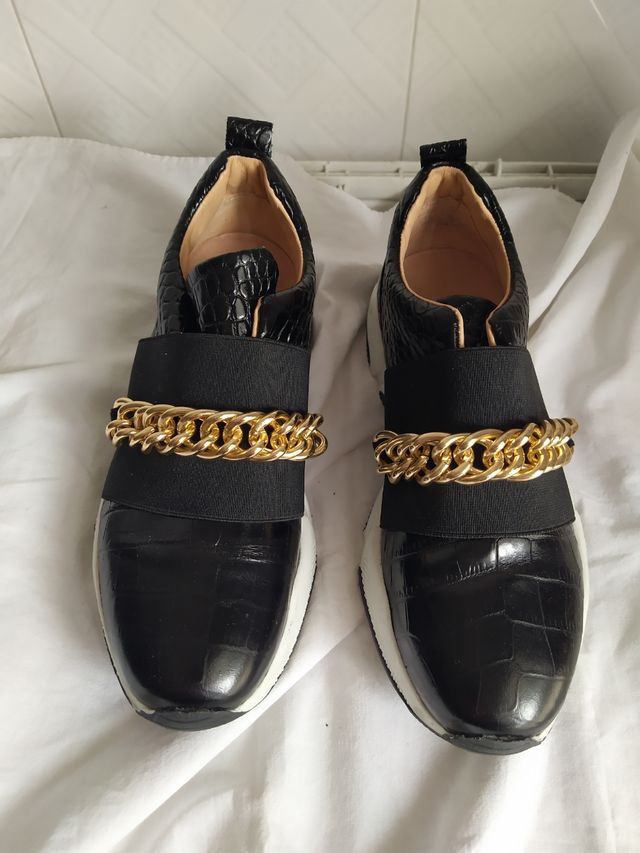 Sneakers negras con cadena dorada