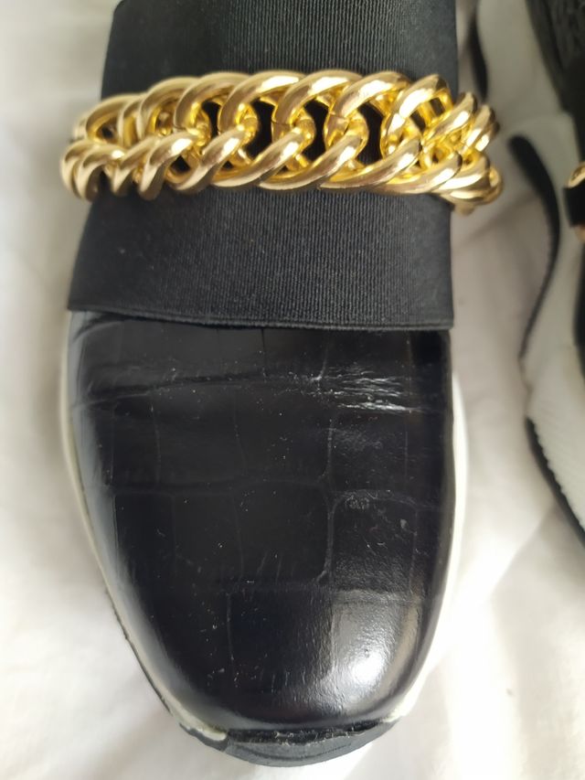 Sneakers negras con cadena dorada