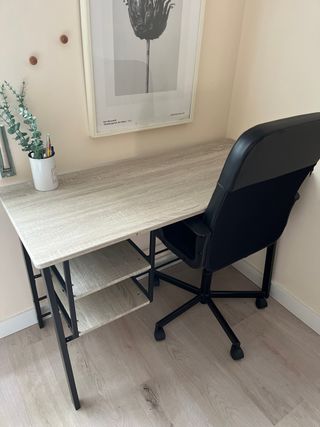 Escritorio color madera con silla negra.