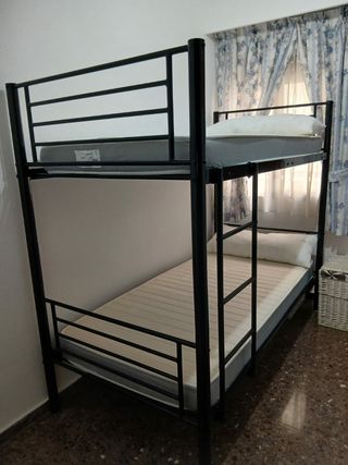Litera metálica negra, con colchones y almohadas