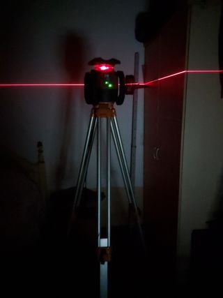 Un nivel laser con el tripoli,y las baterias
