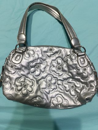 Bolso plateado con flores