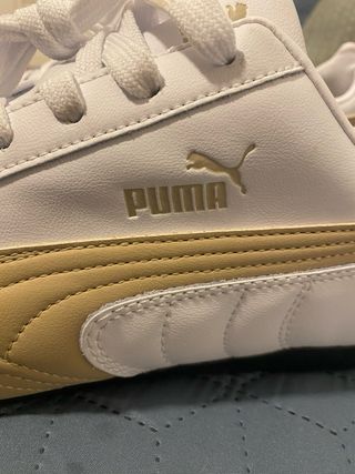 Zapatillas Puma blancas y doradas