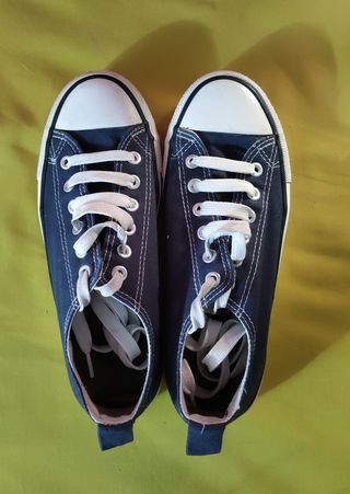 Zapatillas tipo Converse bajas azules.