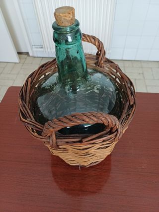 Garrafa antigua de vidrio en cesta