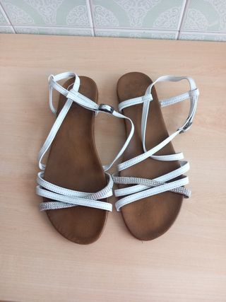 Sandalias planas blancas y marrones