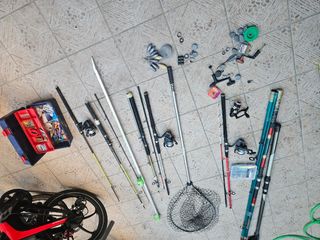 Cañas de pescar usadas y dos redes de sacar el pez