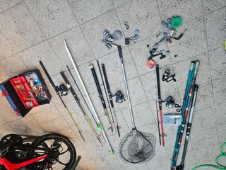 Cañas de pescar usadas y dos redes de sacar el pez