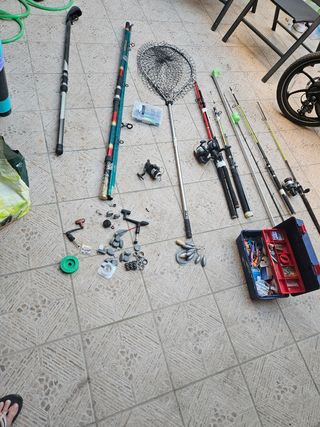 Cañas de pescar usadas y dos redes de sacar el pez