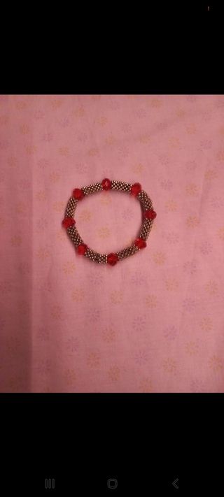 Pulsera dorada con piedras rojas