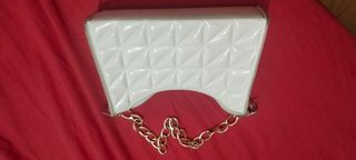 Bolso blanco con cadena dorado.