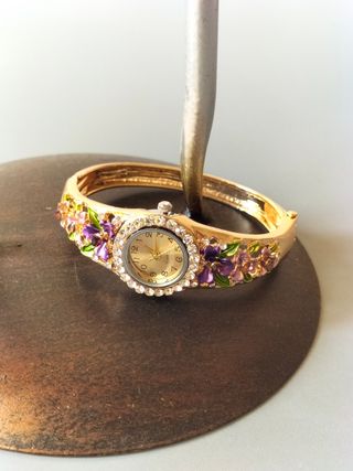 Reloj pulsera dorado con flores