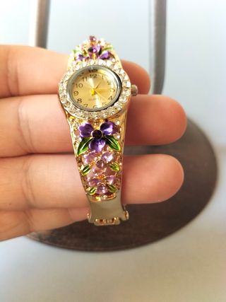 Reloj pulsera dorado con flores