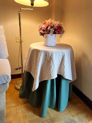 Mesa redonda de madera, vestida de  beige y verde